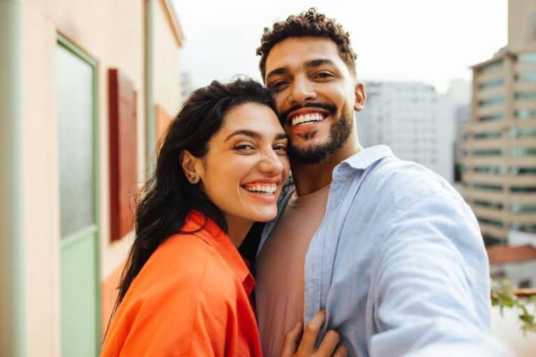Happy couple embracing outdoors after successful dental implant procedure in Colorado Springs
