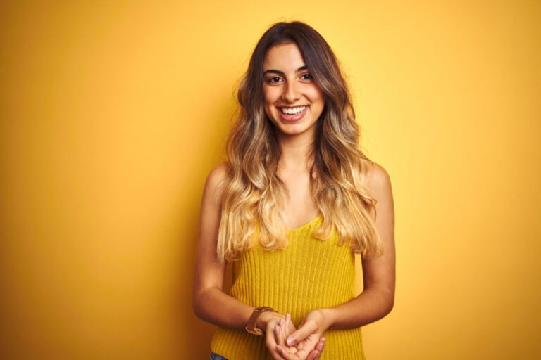 Young woman with fingers crossed hoping to qualify as ideal dental implant candidate in Colorado Springs