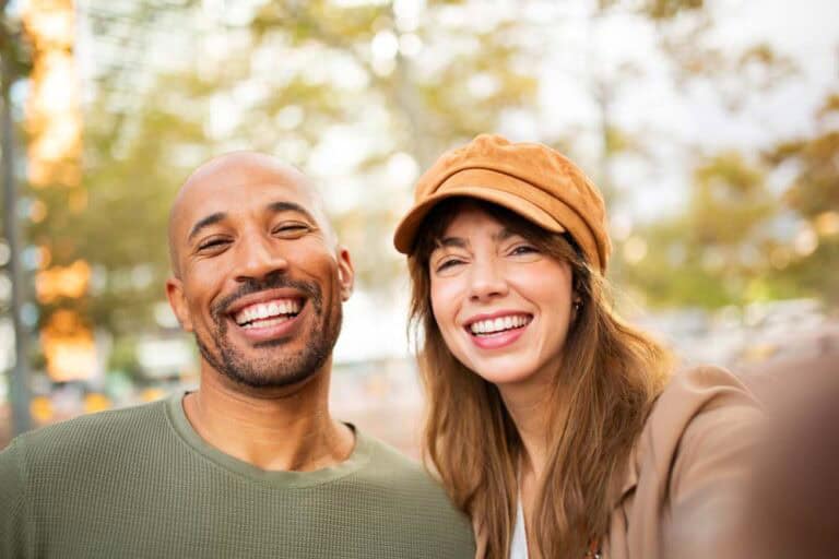 Happy couple taking selfie showing healthy smiles supported by dental implants in Colorado Springs