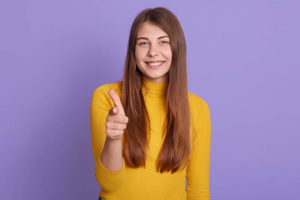 Woman celebrating successful dental implant aftercare in Colorado Springs, CO