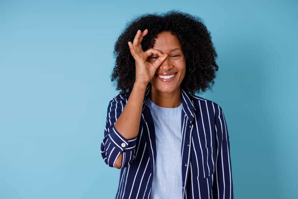 Happy woman giving OK sign promoting good oral health habits at home in Colorado Springs, CO