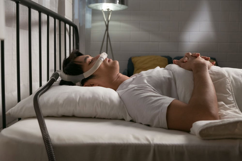 Man sleeping with CPAP machine for sleep apnea treatment in Colorado Springs, CO