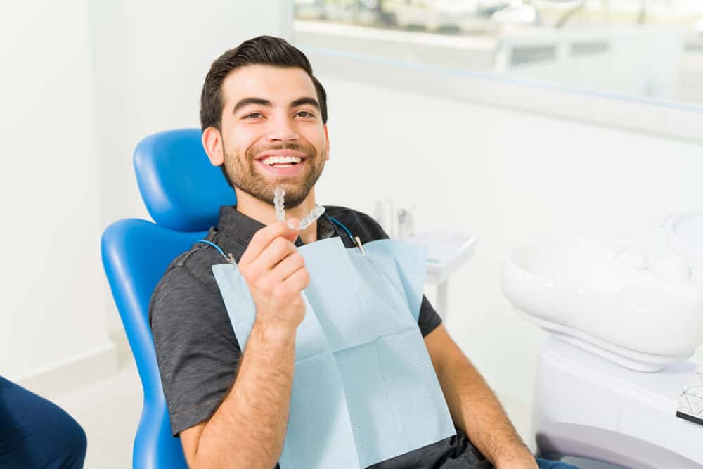 Young man wearing SureSmile clear aligners during orthodontic appointment in Colorado Springs, CO