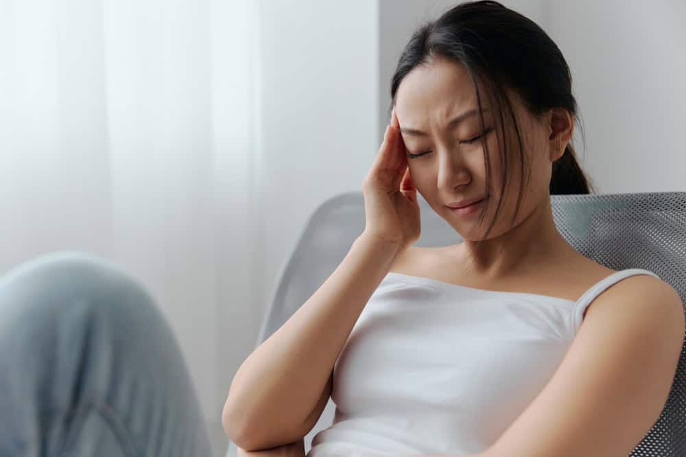 Woman holding jaw in pain from TMJ disorder seeking treatment in Colorado Springs, CO